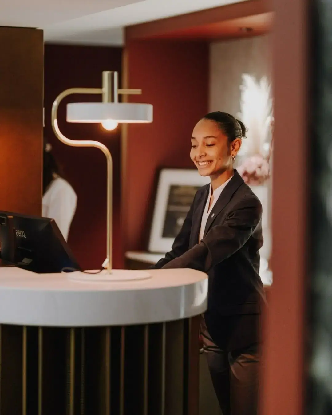 Smiling host at a boutique reception desk