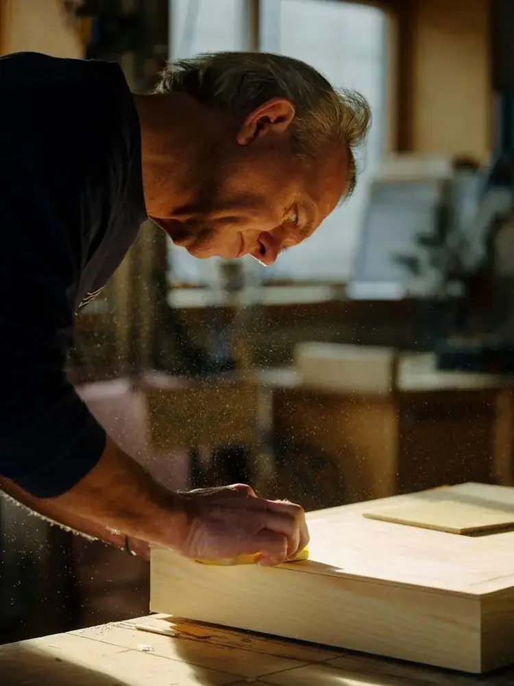 Craftsman finishing a wooden piece in his workshop