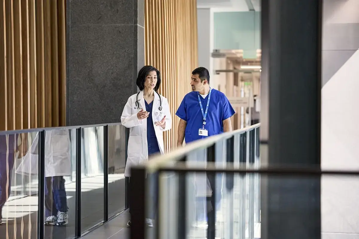 Doctor and colleague talking as they walk through a hospital