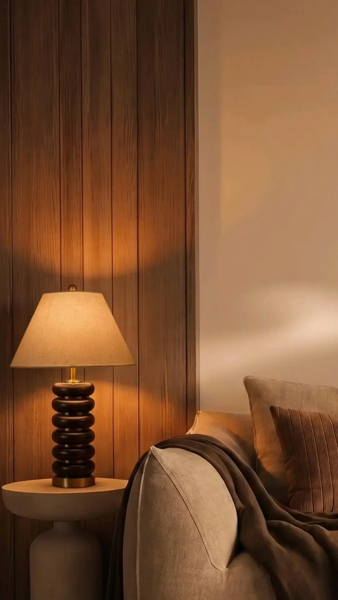 Table lamp glowing against a timber-panelled wall