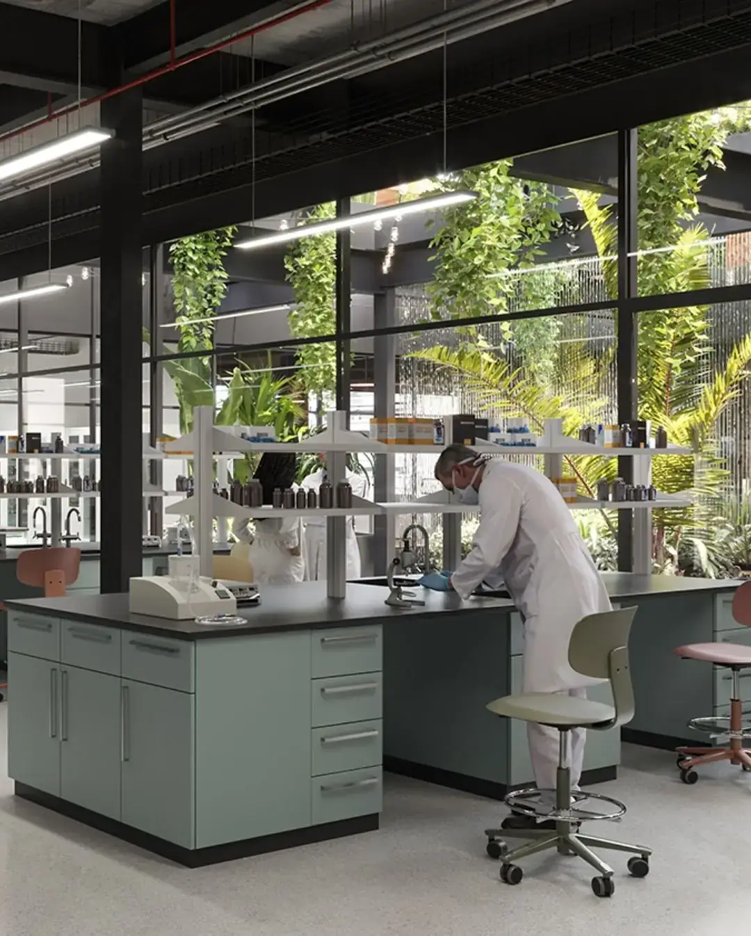 Scientist working at a laboratory bench beside a planted atrium