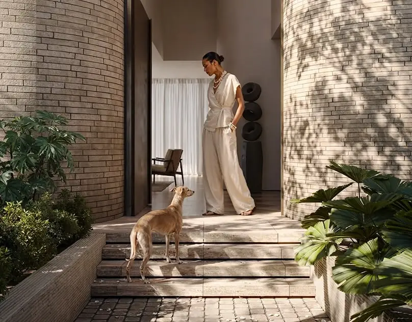 Woman with her dog at the entrance of a luxury home