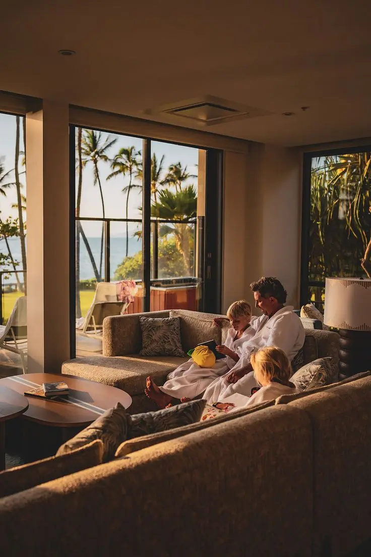 Family relaxing in a hotel suite overlooking the ocean