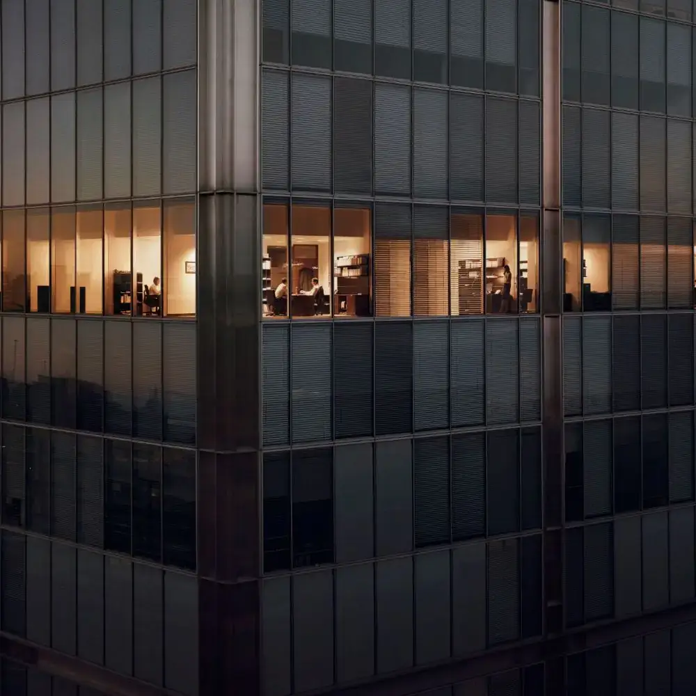 Lit office windows in a corporate building at night