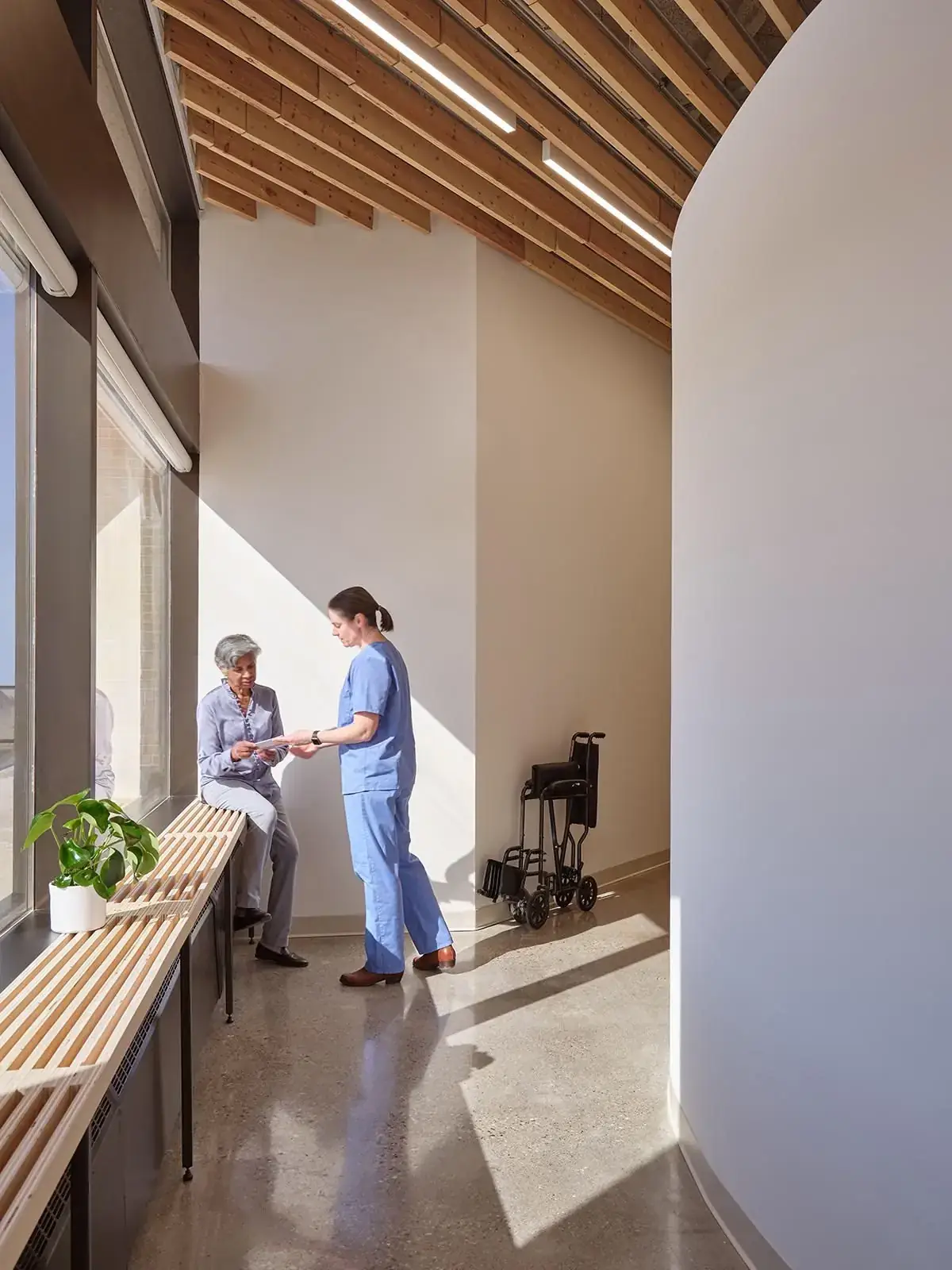 Nurse talking with a patient beside a sunlit window