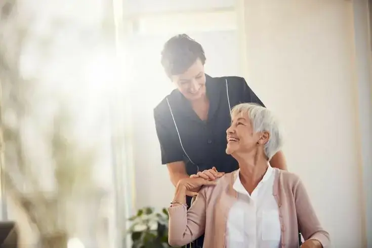 Caregiver reassuring a smiling senior patient