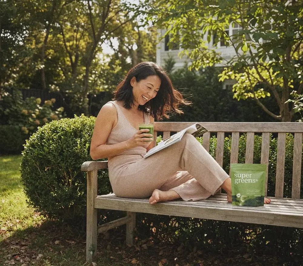 Woman enjoying a green wellness drink in a garden