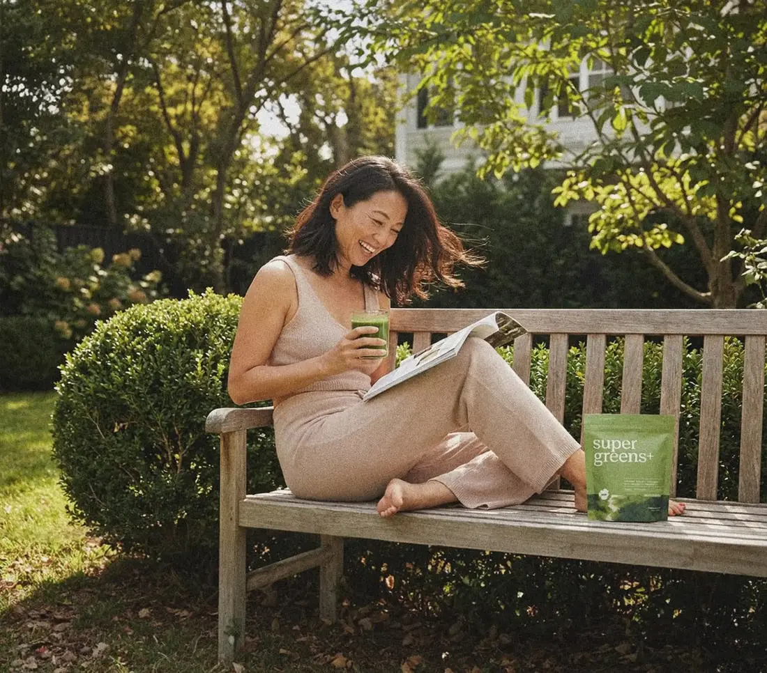 Woman enjoying a green wellness drink in a garden